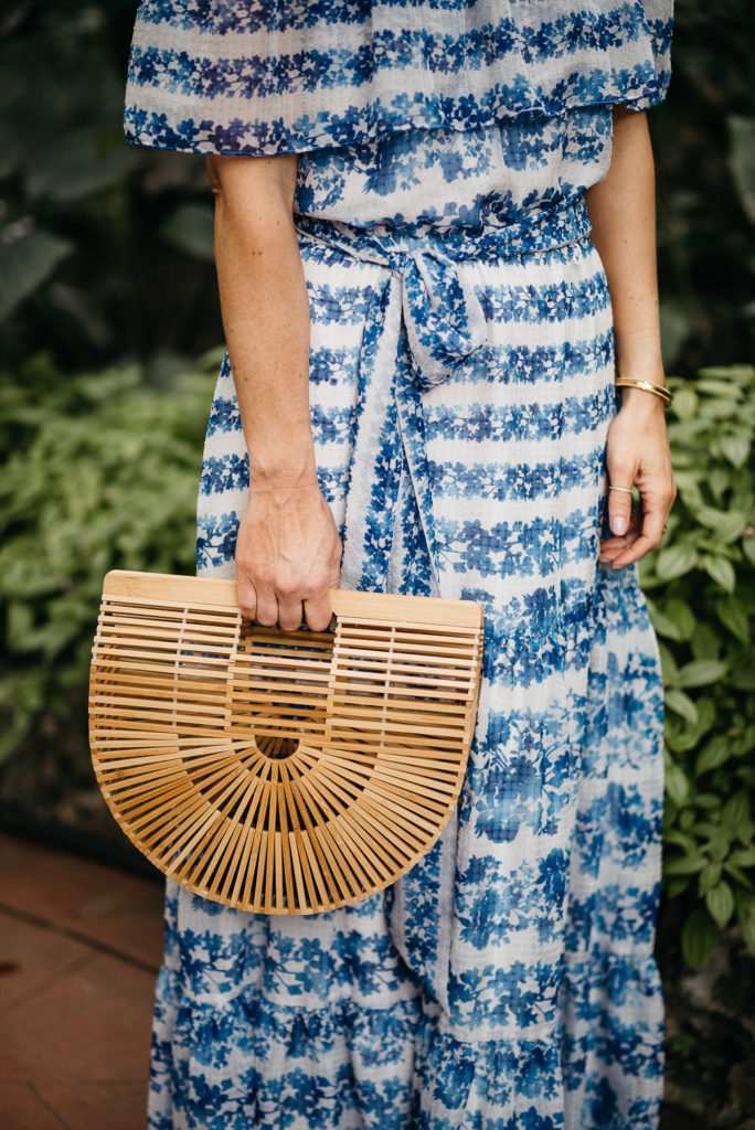 woman wearing maxi dress and holding  weaved bag