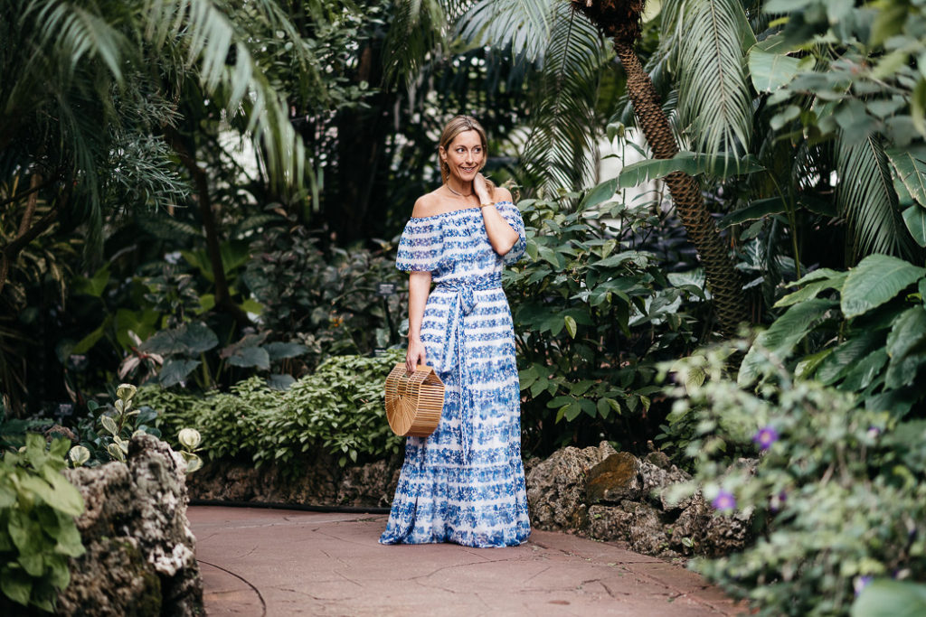 woman holding her hair and wearing blue and white striped Maxi Dress