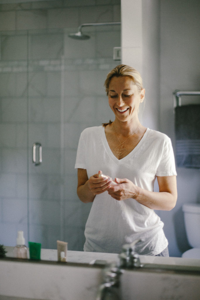 woman in a bathroom holding a beauty Clean Beauty Brands