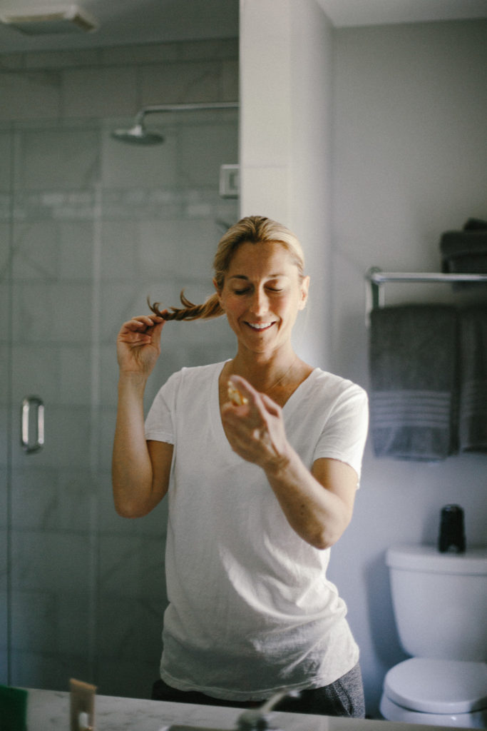 woman spraying beauty product on her face