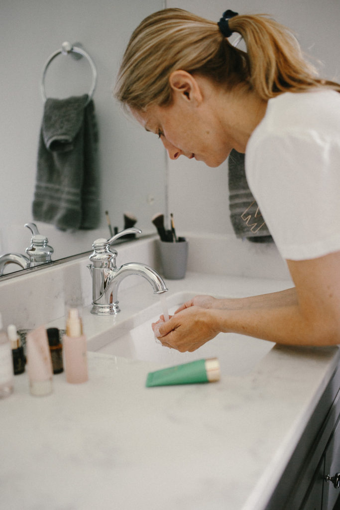 woman washing her face with Clean Beauty Brands