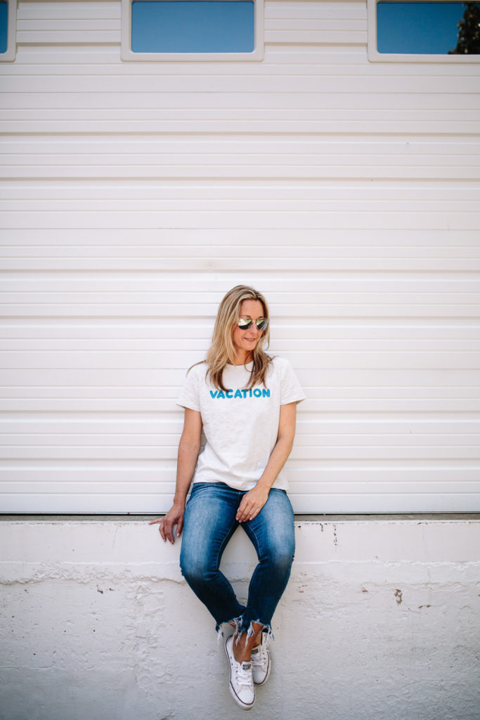 woman spending Summer in Chicago and sitting on down wearing shirt and jeans