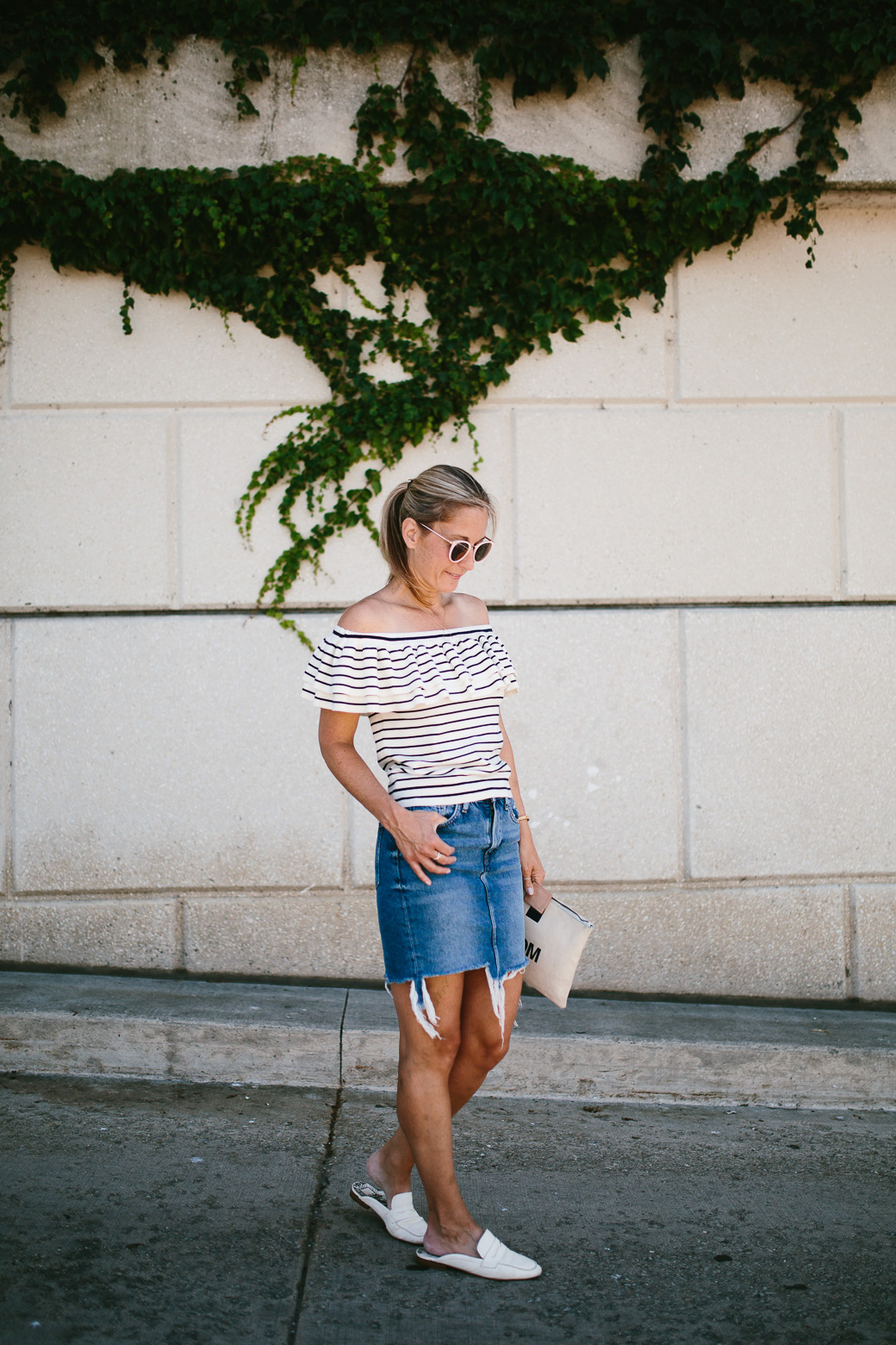 woman wearing denim skirt, striped top and white slides 
