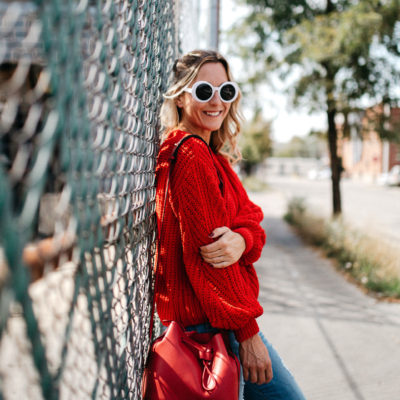 5 Sweaters Needed For Fall include this lovely knitted red sweater and blue jeans