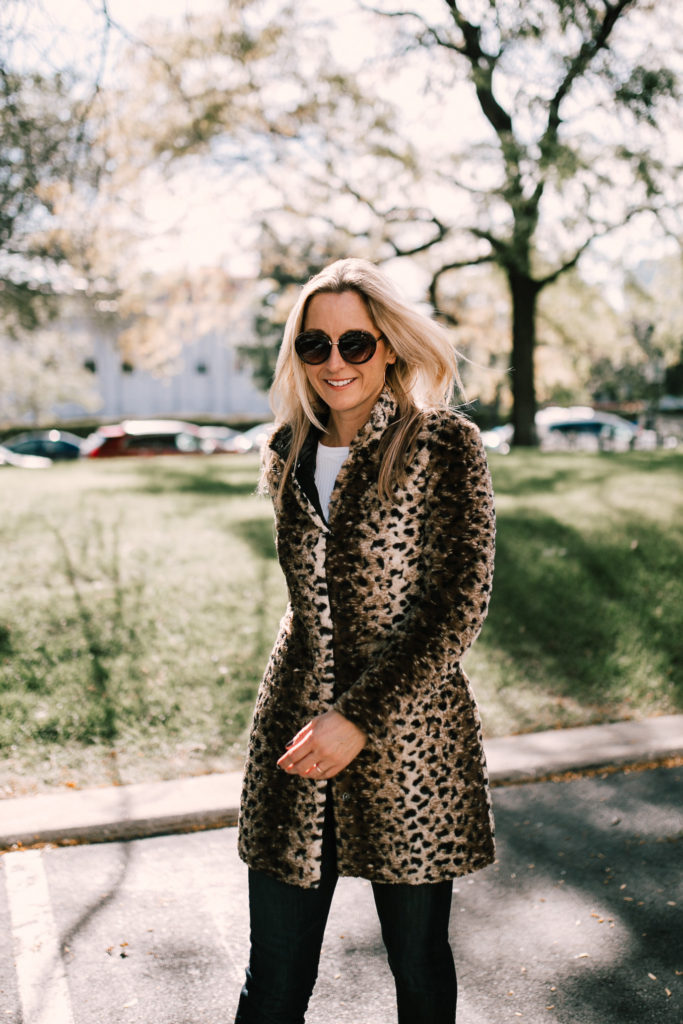 woman smiling and wearing a Leopard print jacket