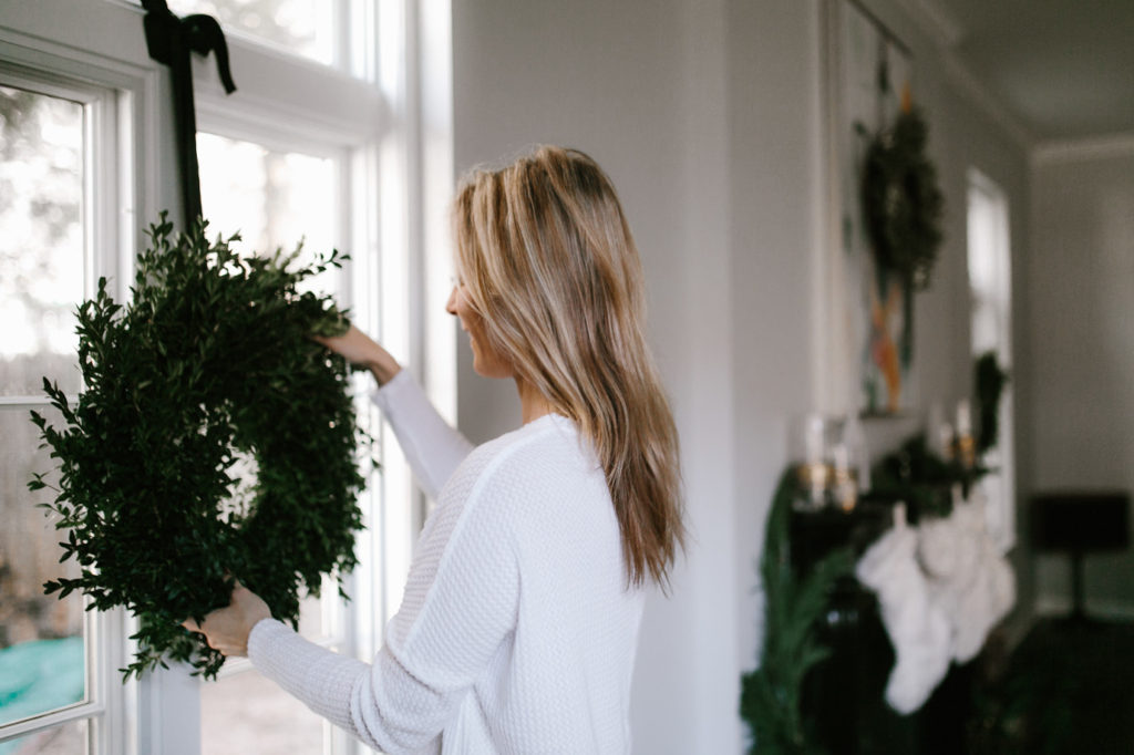 Hanging wreaths on window as a way to upgrade your holiday decor