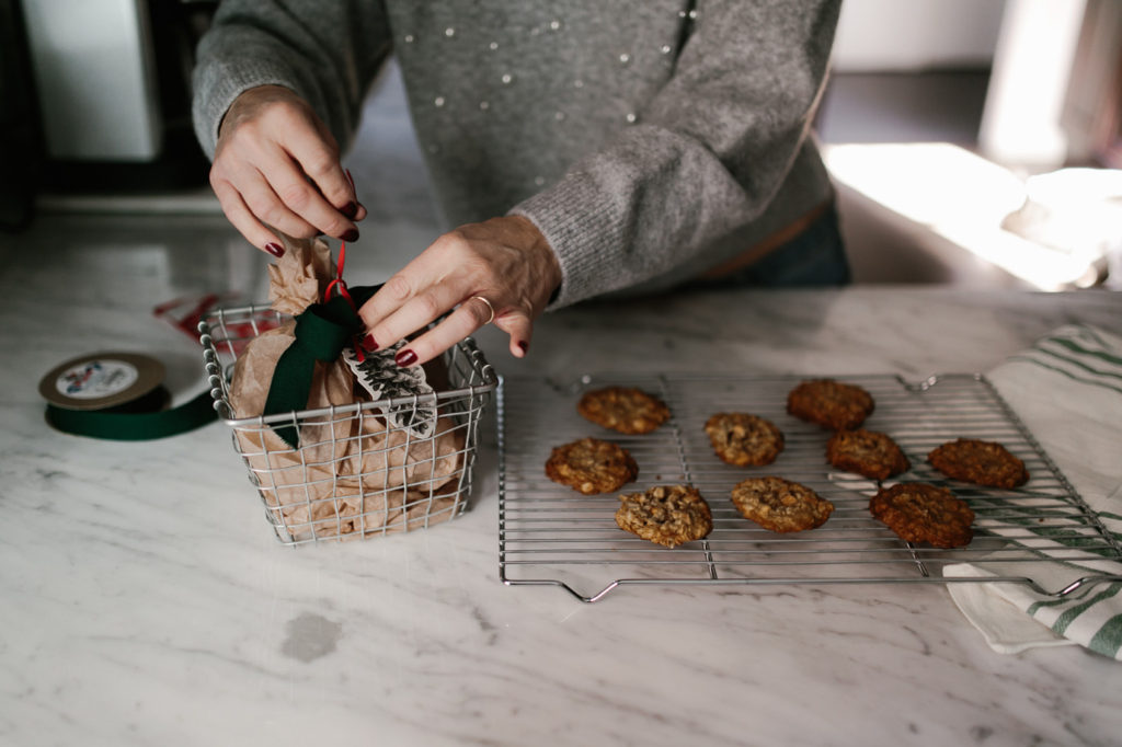 Presentation of a simple holiday cookie with wire basket, wax paper, gift tag and ribbon