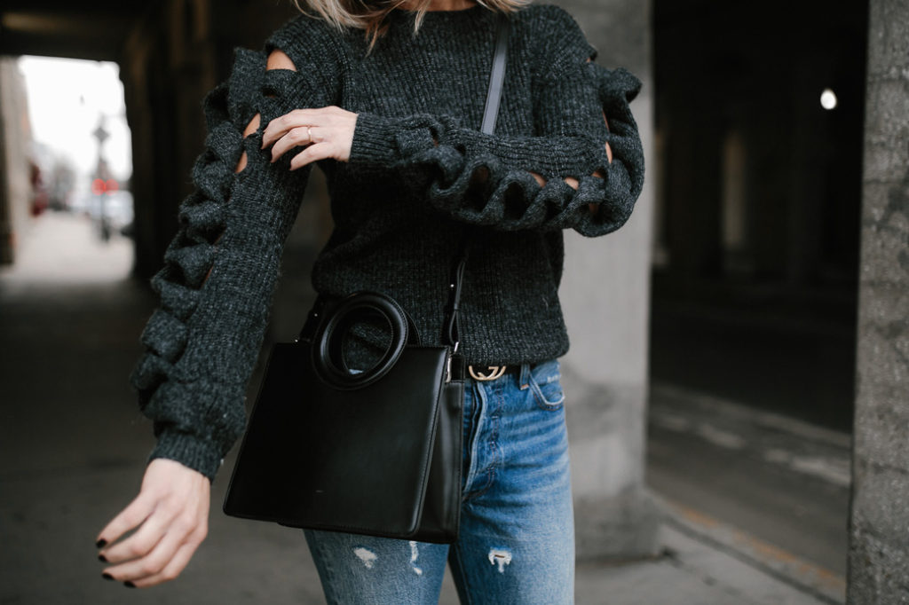 woman wearing go sweater night with twists and jeans 