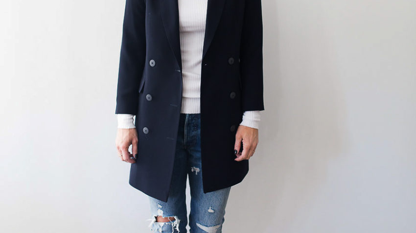 A pair of reto sneakers completes the look of a longer version navy blazer with a white top and distressed denim