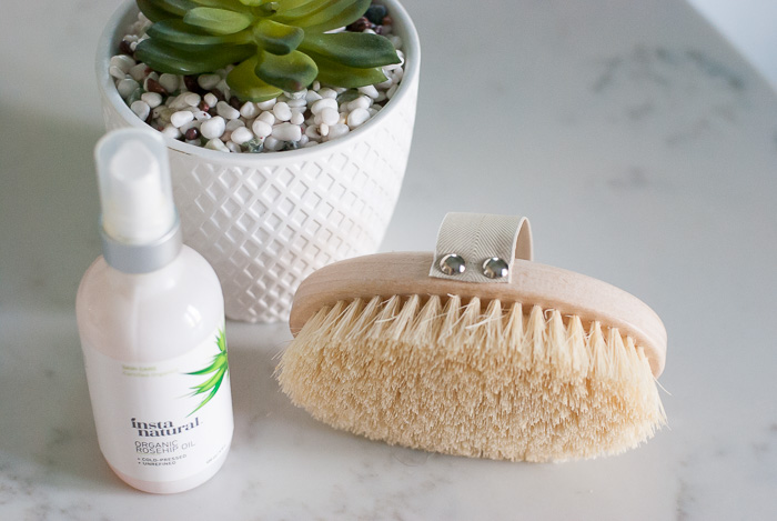 dry brush, bottle, and plant for Benefits of Dry Brushing 