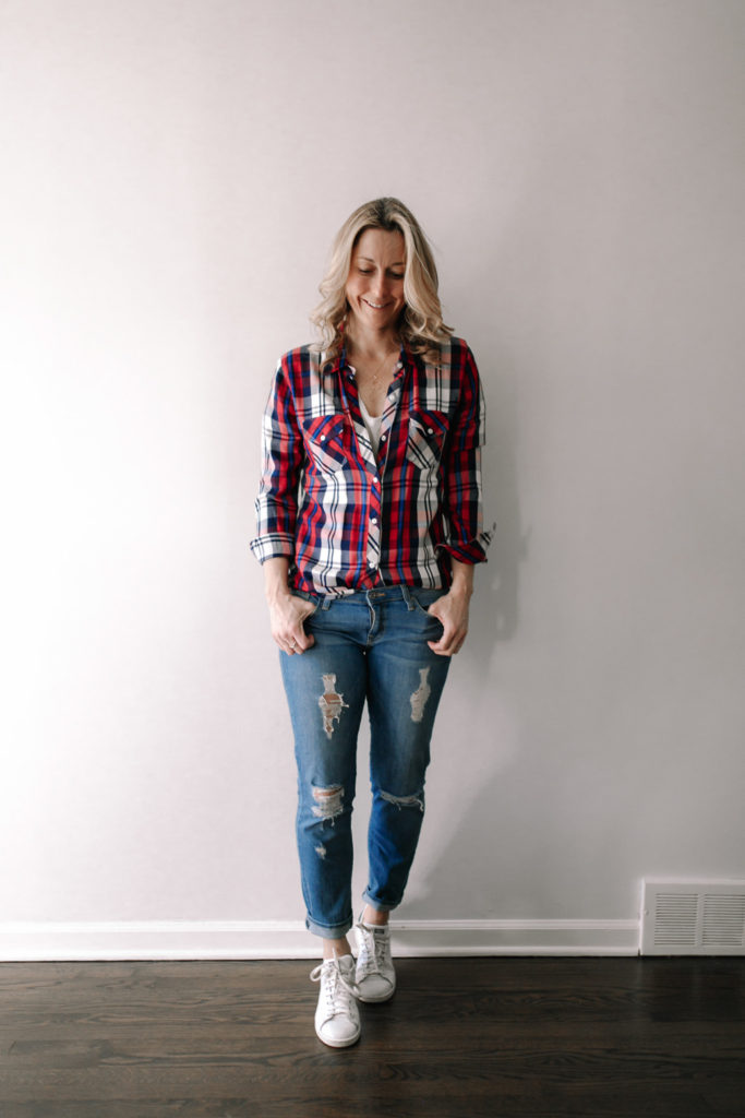 woman Accessorize with a gold necklace and white street style sneakers and Transitioning Seasons With stripes