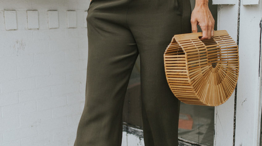 Cult Gaia large bamboo bag paired with olive green palazzo pants and ivory silk tank