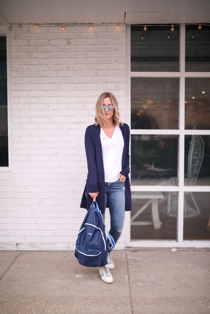 Megan Medica is wearing a Side Notch Pocket Duster Cardigan, and a white tee and jeans outfit 