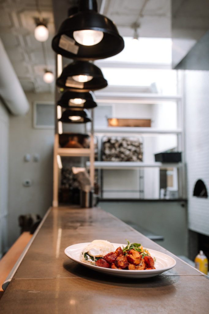 the sweet potato and eggs guildhall brunch plate served on a long counter top with overhead lights