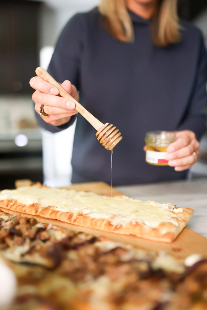 person adding honey on flatbreads